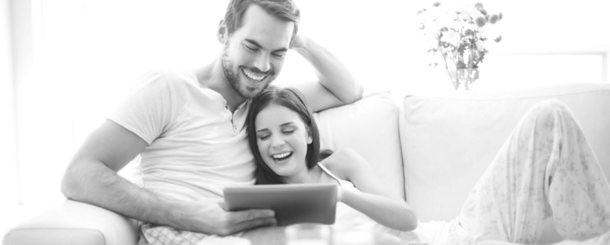 Notizblock mit handgeschriebenen Finanzzielen neben digitaler Kalenderansicht